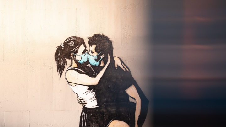 Graffiti eines sich küssenden Paares mit Maske